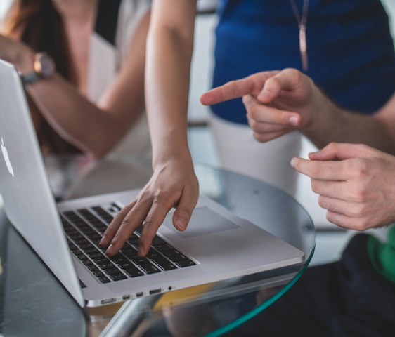 person touching and pointing MacBook Pro